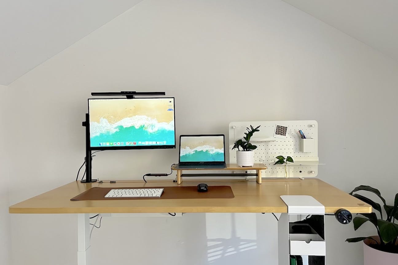 A picture of a laptop and monitor on the stand up desk